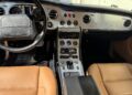 The interior of the rare Bentley Turbo RT Mulliner showcases a luxury dashboard with circular air vents, an elegant control panel, and exquisite tan leather seats.