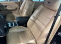 The interior of the Bentley Turbo RT Mulliner is a rare masterpiece, featuring beige leather seats, a central black armrest, and chrome accents on the controls that exude power and luxury.
