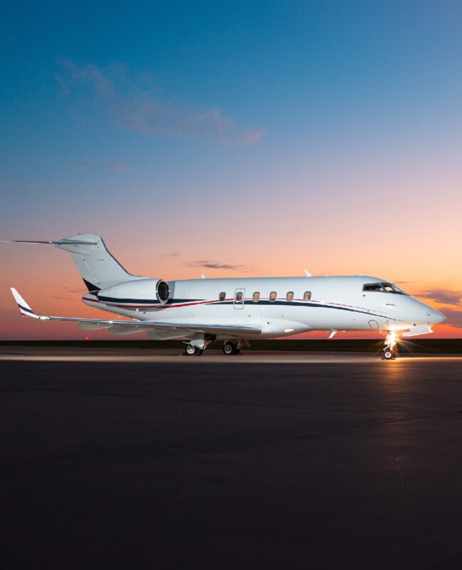 A sleek private jet rests on the runway at sunset, with a clear sky painting the perfect backdrop. Featured in the 2025 edition of duPont REGISTRY, this marvel is a testament to modern luxury and innovation in aviation.