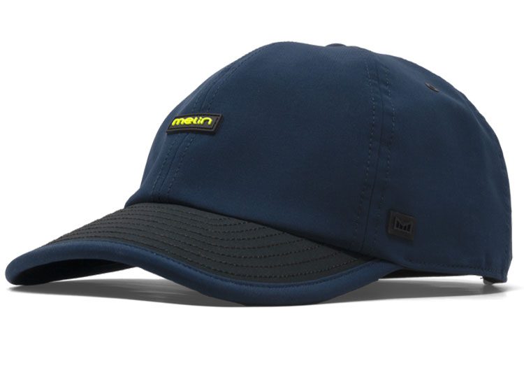 Topi baseball berwarna biru dengan pinggiran hitam dan logo kecil di bagian depan, bagian dari MPH Collection by Melin, menampilkan desain yang terinspirasi dari otomotif.