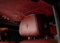 Close-up of a bespoke luxury car interior with red leather seats and a starry ceiling effect, reminiscent of the elegance found in a Rolls-Royce Phantom.