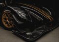 Close-up of a sleek black race car with gold accents and Hankook tires, celebrating Radical Motorsports' 28th Anniversary. The aerodynamic design elements highlight the innovative spirit behind this milestone machine.