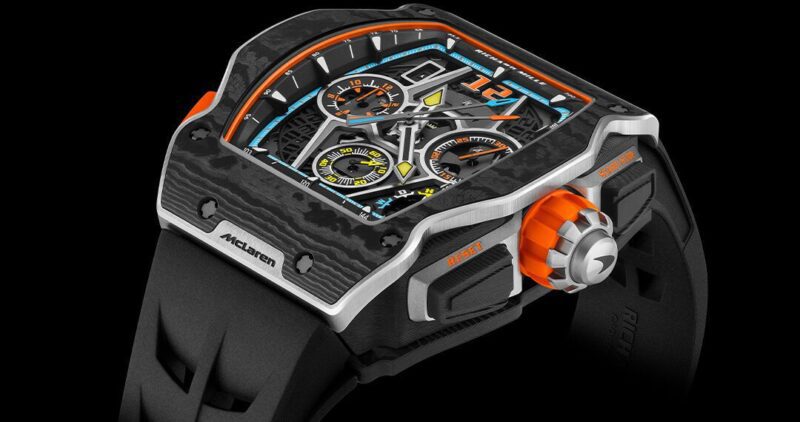 A close view of a luxurious watch showcasing an angular design, featuring an eye-catching black and orange palette, several dials, and a robust black strap that reflects an extravagant lifestyle.