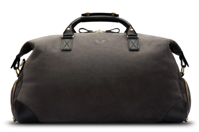 Upgrade your style with this luxurious, dark-colored leather duffel bag. It features black handles and gold hardware, along with side zippers and a subtle logo on the front—a perfect accessory for those seeking elegance.