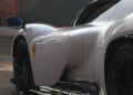 Close-up of a white sports car with sleek curves, featuring the distinctive design elements of the Daytona SP3. Its rear and side profile catch the light on a sunlit road, reminiscent of a historic livery that would make Piero Ferrari proud.