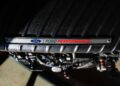Close-up of a Ford engine cover showcasing the striking "Ford Performance" branding in red and metallic, hinting at the power of Megazilla beneath.
