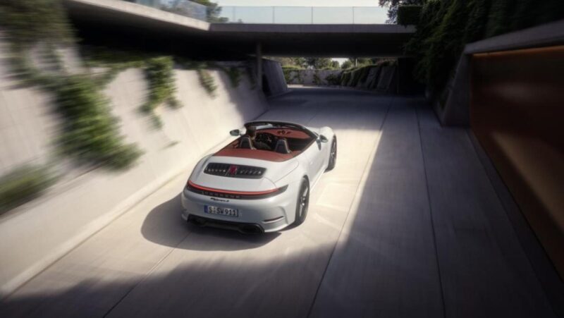 A white convertible sports car drives through a modern, sunlit tunnel surrounded by greenery and contemporary architecture.