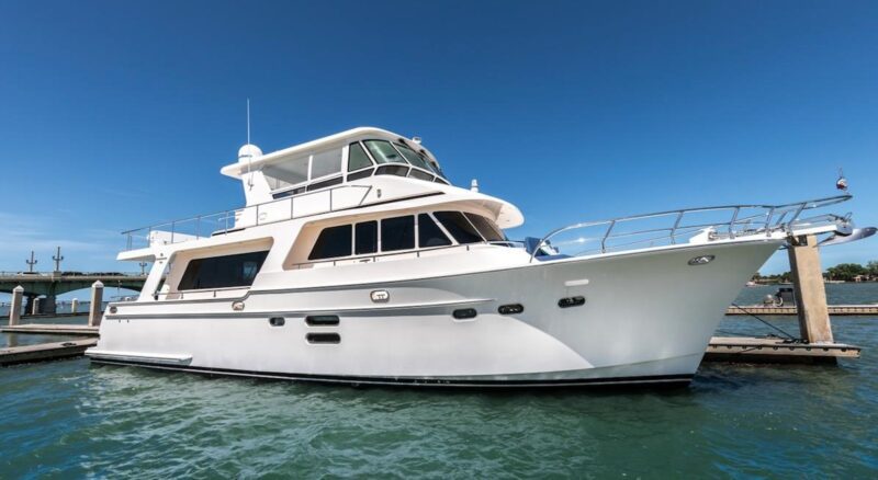 A white luxury yacht docked at a marina under a clear blue sky offers the perfect maritime experience.