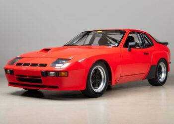 A classic Porsche sports car with black accents and wide tires is parked indoors, facing slightly left against a plain background—a standout choice for any Porsche investment.