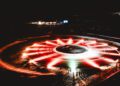 An aerial view captures a circular light display of red and white lights, resembling an ice drifting track in a dark setting. Surrounded by snow and distant buildings, it's reminiscent of a scene ready for a Guinness World Record attempt.