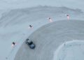 Aerial view of a Porsche Taycan expertly ice drifting on a snowy track, surrounded by six drones emitting red light, possibly setting the stage for a breathtaking Guinness World Record attempt.