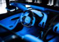 The interior of the Bugatti W16 Mistral unveils a luxury sports car featuring a blue steering wheel, blue accents, and sleek black controls.