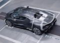 A black Bugatti sports car, adorned with precise sensors and markings, undergoes rigorous aerodynamic testing in a wind tunnel.