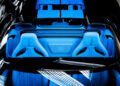 Top view of a luxury car interior unveils blue and white seats adorned with a central emblem and visible logo, reflecting the opulence of Bugatti's W16 Mistral design.