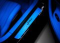 In the low blue lighting, Bugatti unveils a sophisticated touch: a close-up of the illuminated door sill plate, proudly inscribed with "Mistral," adjacent to a luxurious leather seat.