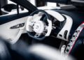 The luxurious interior showcases a sleek steering wheel emblazoned with the Bugatti logo, while the modern dashboard flourishes with metallic and leather accents, reminiscent of the W16 Mistral’s unparalleled design.