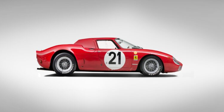 Side view of a red vintage sports car, reminiscent of a Ferrari 250 LM with the number 21 on the side, boasting a sleek, aerodynamic design that echoes its Le Mans-winning legacy against a neutral background.