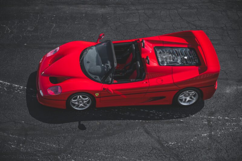 Overhead view of a red sports car with a convertible top, parked on textured asphalt—a perfect centerpiece for any duPont REGISTRY feature.