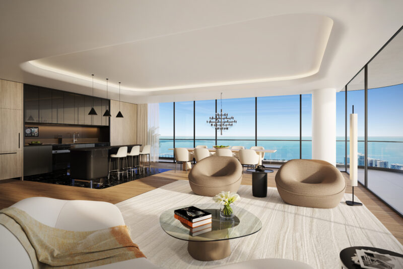 Modern open-concept living area in Tower 2 with large windows offering an ocean view. Features include a kitchen with bar seating, a dining table, and circular chairs on a light rug. Explore Miami Real Estate to make this stunning residence your own.