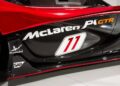 Close-up of a red McLaren P1 GTR, a track-only hypercar, showcasing the side panel with the number 11 and sponsor logos like McLaren, AkzoNobel, and SAP.