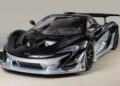 A sleek black and silver McLaren P1 GTR, showcasing its prominent rear wing and aerodynamic features, stands indoors. This hypercar is a testament to engineering excellence and is now available for sale.