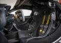 Inside the McLaren P1 GTR, the track-only hypercar marvel, you'll find a single black racing seat with striking yellow harnesses, carbon fiber accents, and an intricate steering wheel.