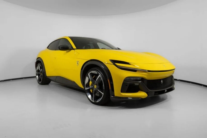 A yellow sports car with a sleek design, reminiscent of the Ferrari Purosangue SUV, is parked in a white-walled room.