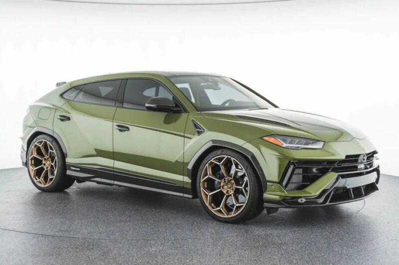 A green luxury Lamborghini Urus with bronze alloy wheels is showcased in a well-lit studio setting, exemplifying the pinnacle of SUVs for sale.