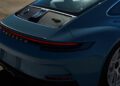 The rear view of a blue Porsche 911 S/T sports car showcases its distinctive taillights and branding on a smooth, sunlit surface, making it a perfect auction highlight at RM Sotheby's.