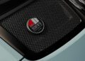 Close-up of a car engine cover with a black mesh grille featuring a circular badge that boasts a red, white, and grey design with the text "50" and "Porsche 911 S/T," highlighting the classic allure this model brings to RM Sotheby's prestigious auctions.