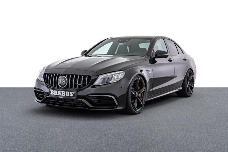 A sleek black Brabus-modified luxury sedan, a unique creation among custom cars, is parked on a grey surface, viewed from a front angle.