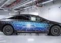 A sleek electric car sits in a well-lit garage, featuring "Solid State" on its side. Engineered with advanced EV battery technology, it embodies the precision akin to Mercedes-Benz craftsmanship or innovations by F1 engineers.