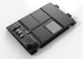 Black modular electronic component featuring multiple sections, connectors, and metallic rods on a pristine white background. Crafted with precision akin to that of F1 Engineers, it represents state-of-the-art EV Battery Technology inspired by Mercedes-Benz innovation.