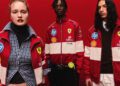 Three models showcase the 2025 Replica Collection, wearing striking red and white racing jackets adorned with sponsor logos, set against a solid red backdrop. This ensemble celebrates the PUMA x Scuderia Ferrari collaboration’s 20th Anniversary.