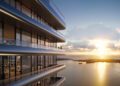 Modern building with glass balconies in Tower 2 overlooking a large body of water at sunset. Two people stand on a balcony, enjoying the scenic view of the Miami Real Estate horizon and sky.