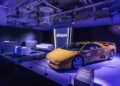 A yellow Lamborghini, part of the Lamborghini Polo Storico collection, is displayed in a showroom with purple lighting. The area features a seating arrangement and a branded backdrop celebrating the rich heritage of this iconic marque.