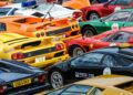 At a Global Celebration, an exquisite collection of colorful sports cars, including Lamborghini models in vibrant yellow, red, orange, and black hues, are parked closely together.