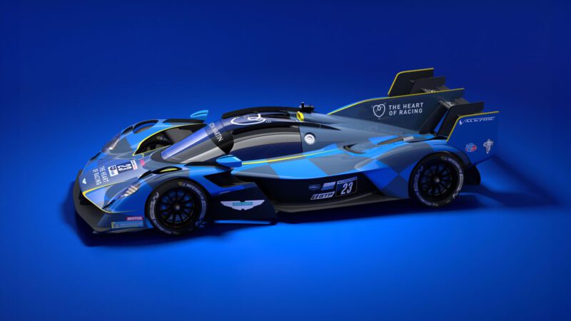 Blue and black racing car with aerodynamic design, number 23, and "The Heart of Racing" logo on a solid blue background. Inspired by the Aston Martin Valkyrie Hypercar, it evokes the thrill of speed as seen at Le Mans.