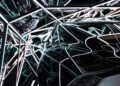 Futuristic abstract installation with reflective surfaces and intersecting neon lights evokes the sleek design of an Aston Martin, creating a complex geometric pattern.
