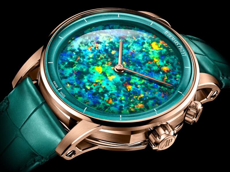 This luxury wristwatch celebrates Audemars Piguet's 150th Anniversary with a turquoise opalescent dial, rose gold case, and green leather strap.