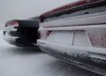 Two Dodge Chargers with frosted exteriors are parked on a snowy surface, snow accumulating on the rear of both world's only AWD muscle cars.