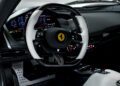 Capture the essence of a Ferrari Daytona SP3's stunning spec with a close-up of its steering wheel, showcased in a luxurious interior. Admire the digital dashboard and control buttons, reminiscent of the opulent designs found at Ferrari of Beverly Hills.