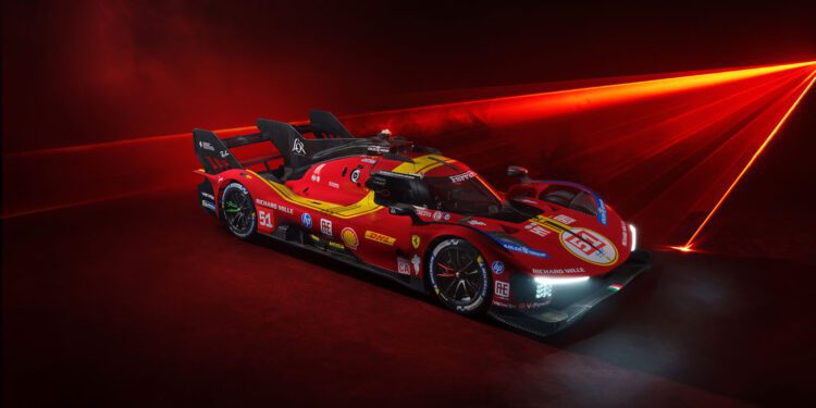 Beneath the intense red lighting, a striking red and yellow Ferrari 499P Hypercar proudly displays its sponsor logos, showcasing its sleek design.