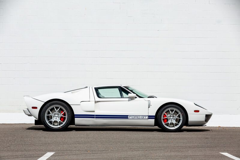 Ford GT 2006 yang murni dengan garis -garis balap biru yang mencolok berdiri dengan elegan di dinding bata putih polos, Aura yang mengisyaratkan drive yang menggembirakan. Siapa yang tidak ingin memenangkan tawaran dengan mahakarya seperti itu?