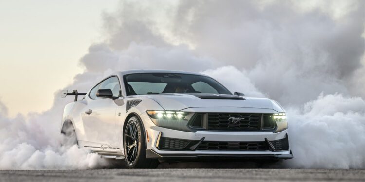 Sports car performing a burnout, surrounded by smoke, on a clear day.