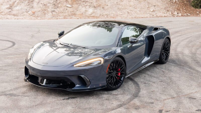 A sleek, gray sports car parked on a road with visible tire marks.