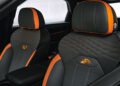 Car interior with two Bentley black and orange leather seats, featuring diamond-pattern stitching, inspired by China, and embroidered crest designs on the backrests from the Mulliner Bespoke Collections.