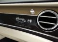 Close-up of a car's dashboard featuring ventilation and a custom design with the text "1 of 3 by Bentley Mulliner," part of China's exclusive Mulliner Bespoke Collections, with decorative elements on a glossy black panel.