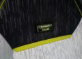 Close-up of a Mansory Atelier label on a black and white patterned fabric, featuring a bold bright yellow accent, reminiscent of the sleek design seen in the Tesla Cybertruck.