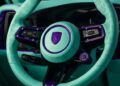 A teal and purple steering wheel with a logo at its center complements the sleek dashboard and interior, echoing the distinct flair of a TECHART-enhanced Porsche Cayenne.
